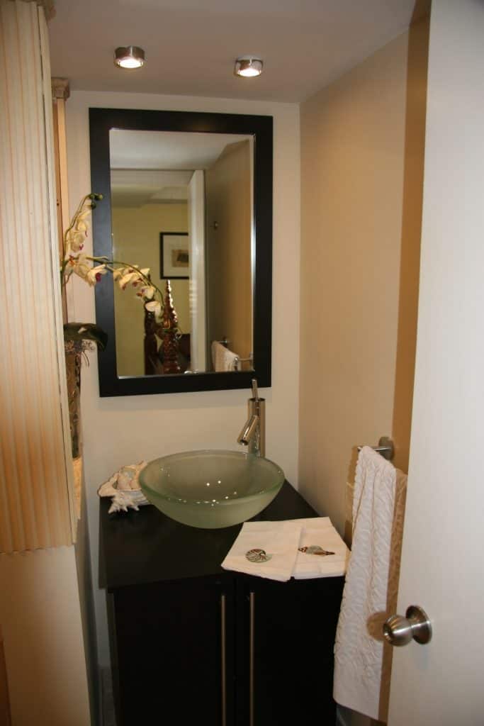 A glass sink in front of a mirror