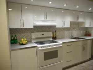 A kitchen with white stove and cabinets