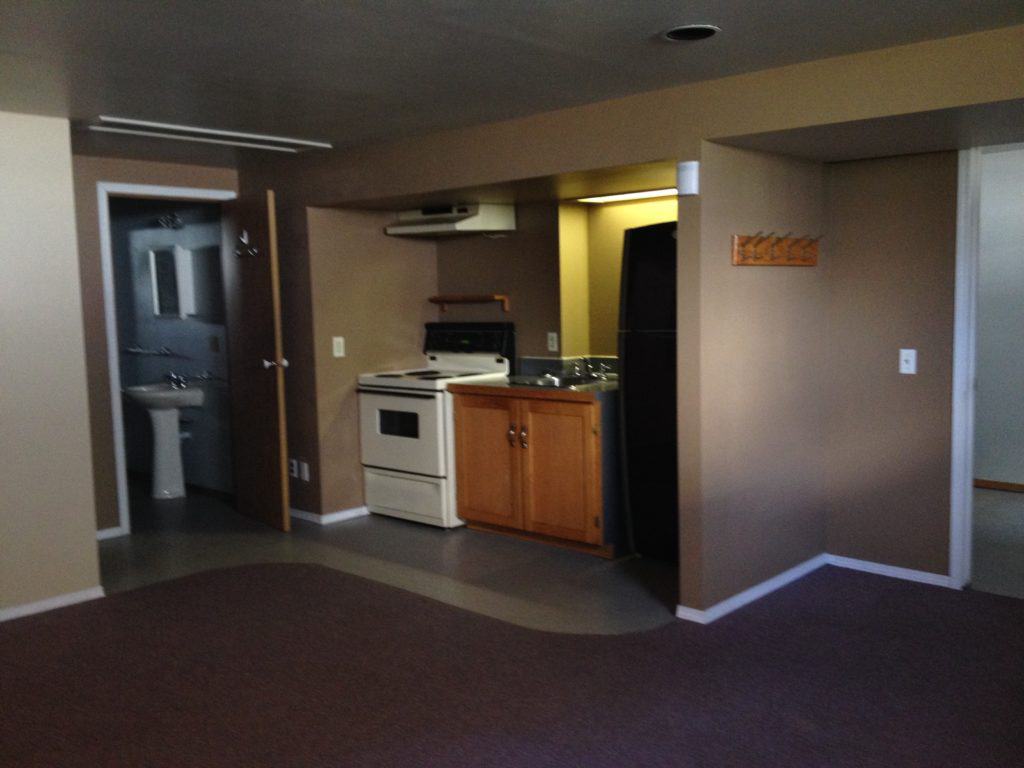 Dark small basement space that needs a kitchen renovation
