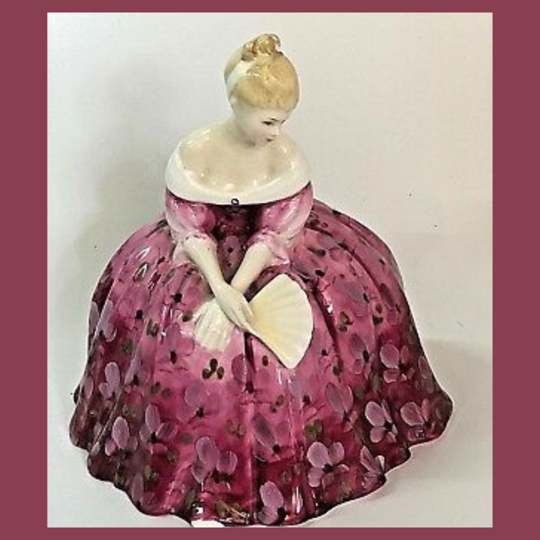 Pink china figurine holding a fan