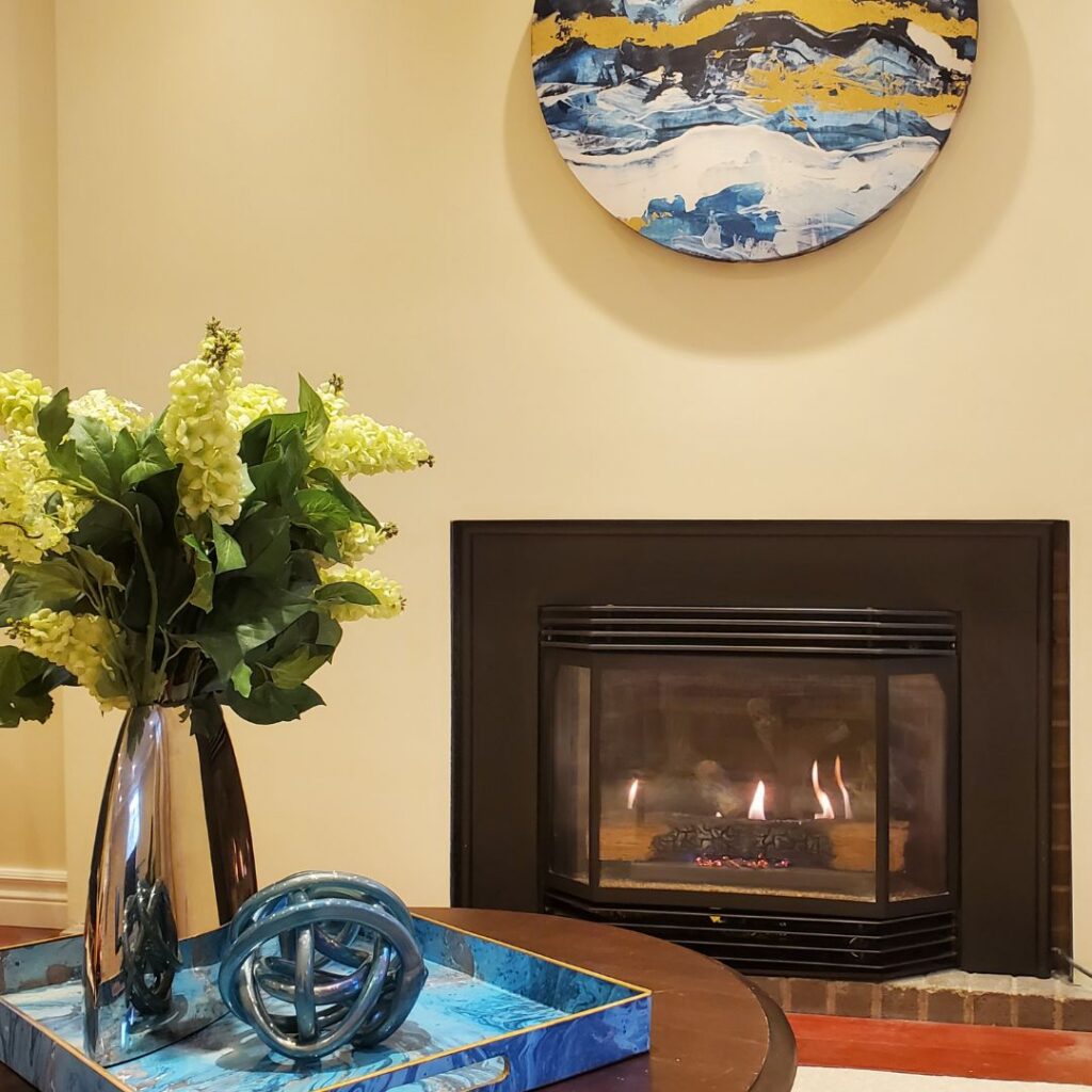 Finished basement renovation with gas fireplace and styled coffee table