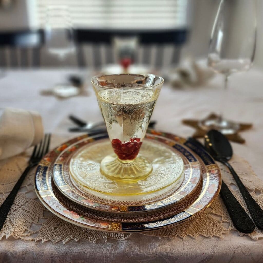Elegant table setting with layered vintage plates and a decorative glass