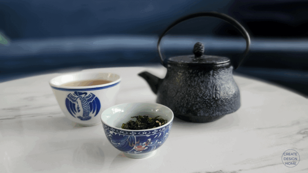 Cast iron teapot with tea cup on a marble surface, photographed to illustrate the Japanese philosophy of Ma.