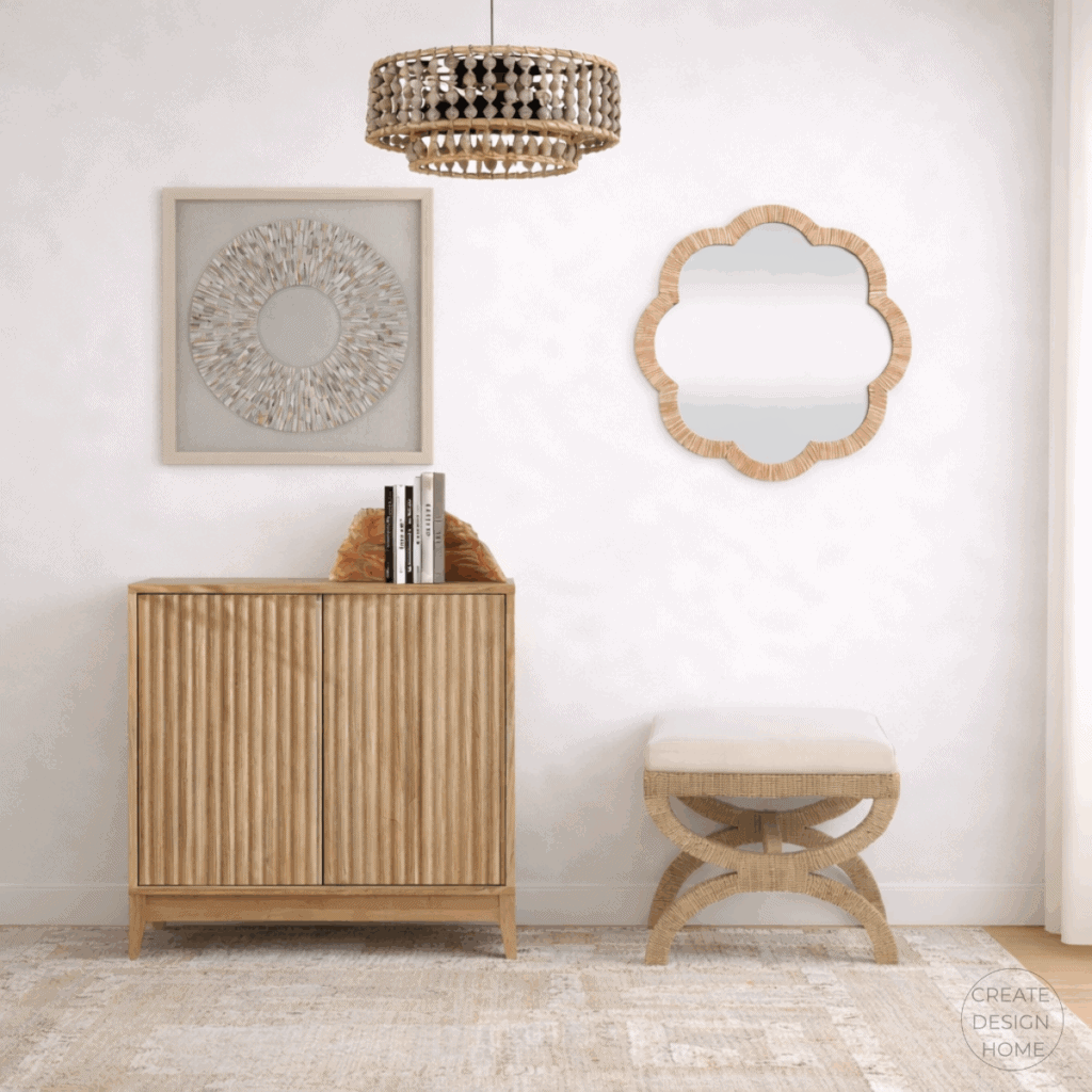Coastal entryway featuring a fluted wood cabinet, woven lighting, sculptural mirror, and neutral textured rug