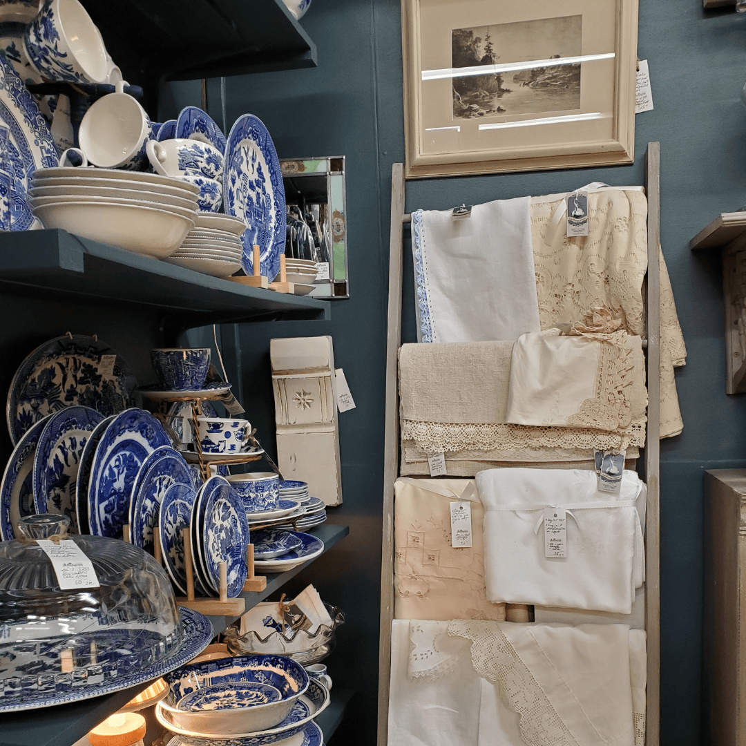 Blue and white dishes and linens displayed on an antique ladder