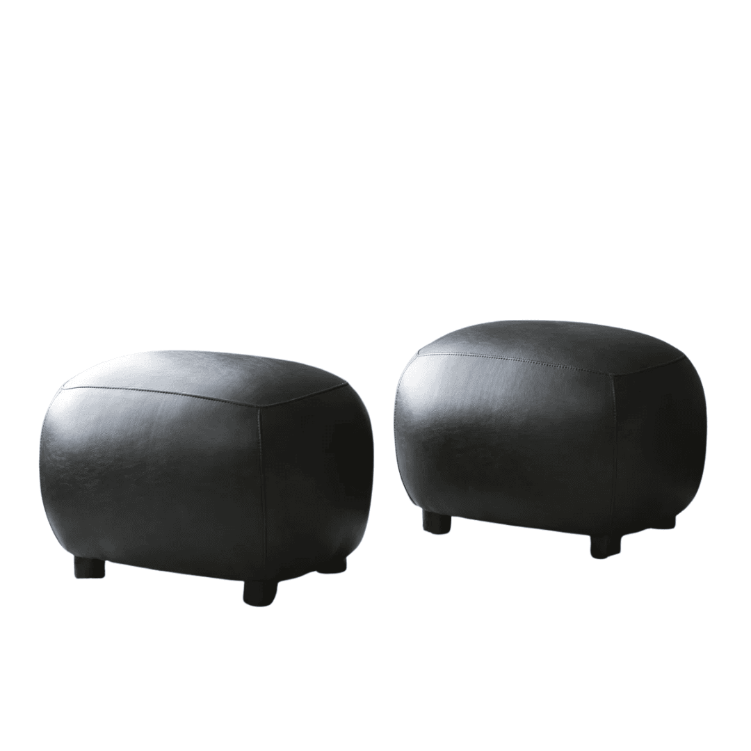 Ottomans Low-profile faux leather ottomans with sculptural presence.
