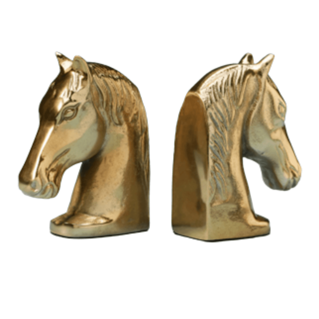 Modern gold colored aluminum horse head bookends on shelf