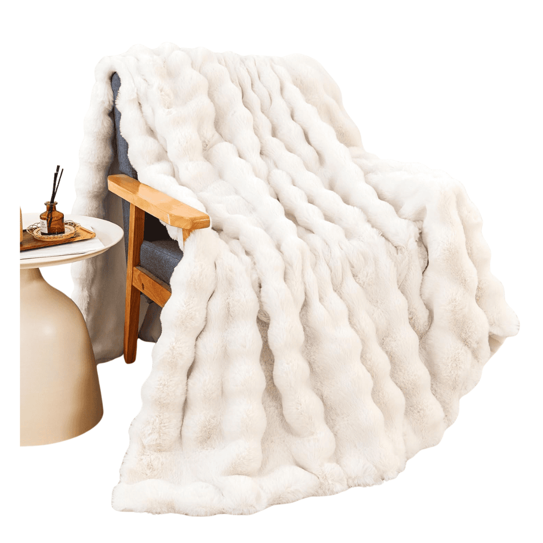 Cream faux rabbit fur throw blanket styled on a bed
