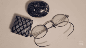 Eyeglasses and textile arrangement reflecting Mushin, calm focus, and thoughtful attention to everyday life.