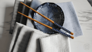Blue patterned bowl with chopsticks and folded linens styled to reflect Shibui, quiet beauty.