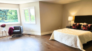 Spacious staged primary bedroom with sitting area and natural light