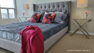 Staged bedroom with upholstered bed, decorative pillows, and neutral decor