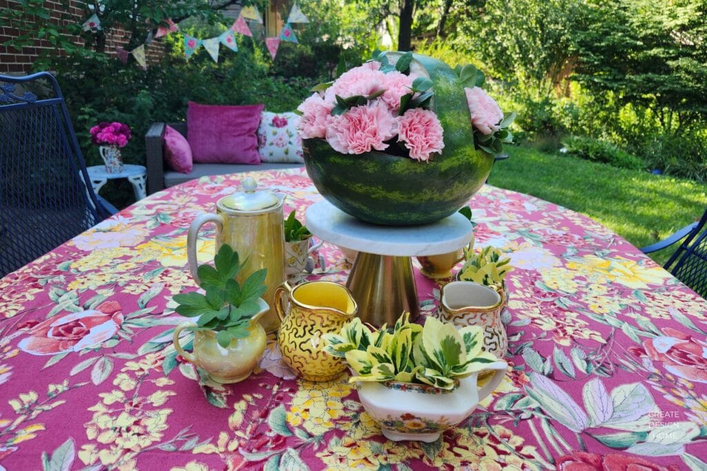 Elegant English country garden tea party with a watermelon floral centerpiece, vintage tableware and colourful summer tablescape.