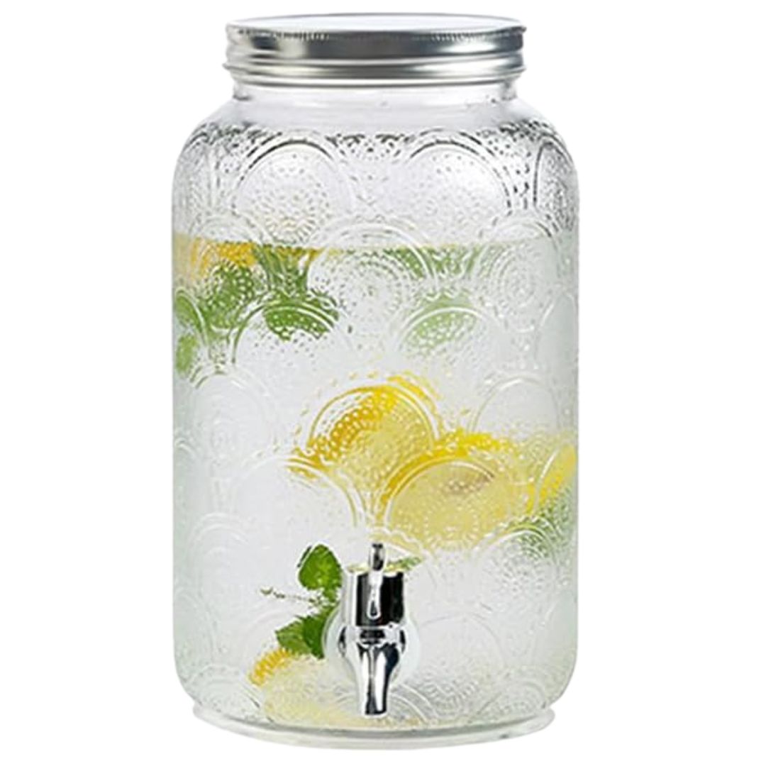 Large glass beverage dispenser for serving summer drinks at a garden tea party.
