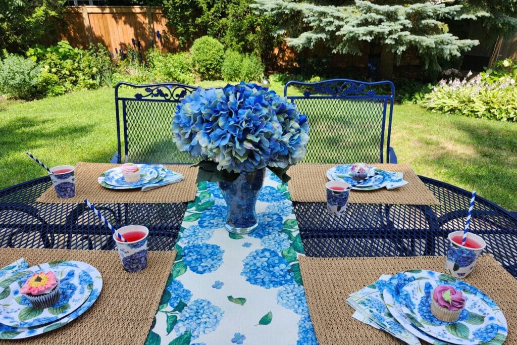 Blue hydrangea-inspired summer table set outdoors in the garden