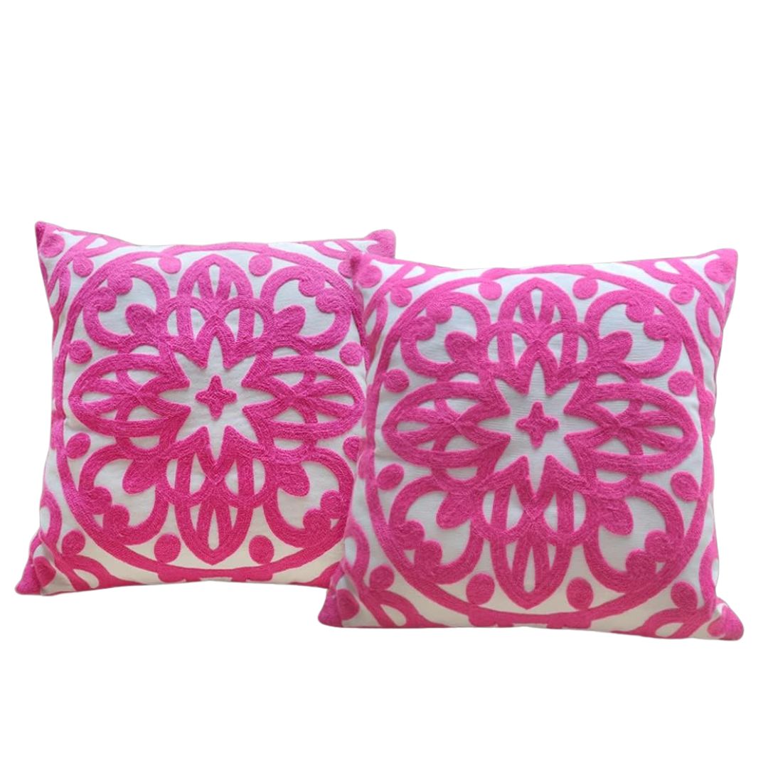 Pink floral embroidered pillows for English country garden seating.