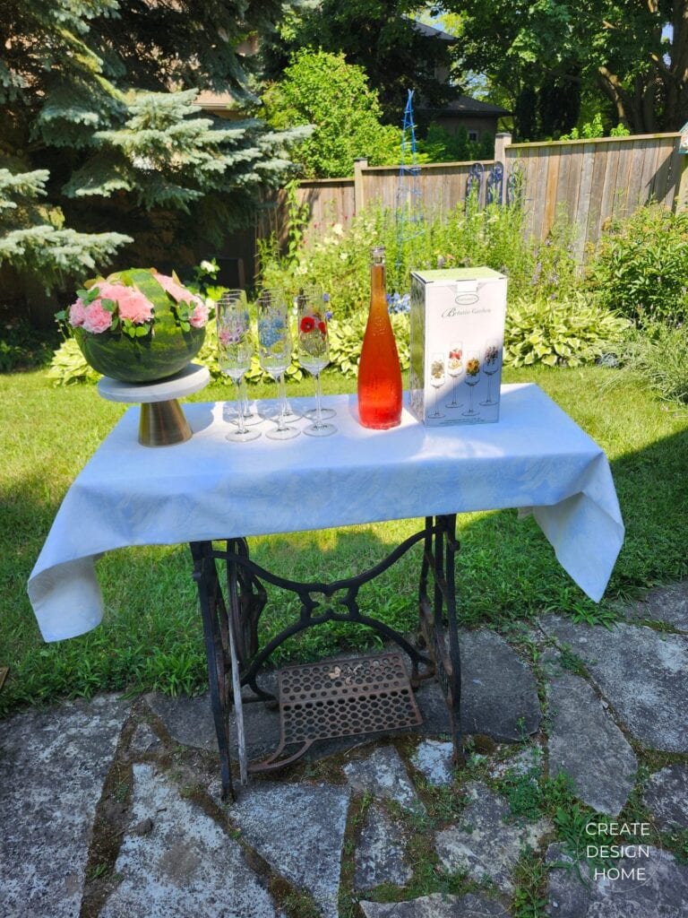 Repurposed vintage sewing machine base used as an outdoor beverage station for a summer garden tea party