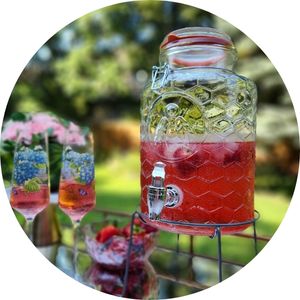 Outdoor beverage station with glass dispenser and refreshing summer drinks.