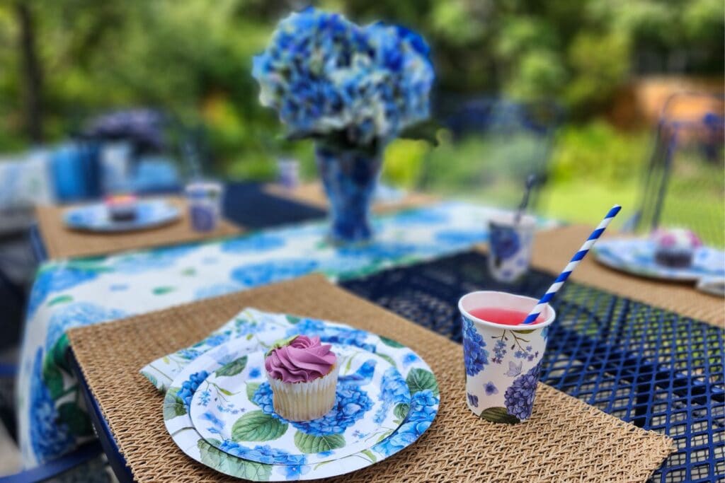 Hydrangea table decor with floral runner, woven placemat and blue tableware