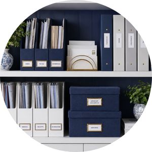 Organized shelving with navy storage boxes, binders and paper organization supplies.