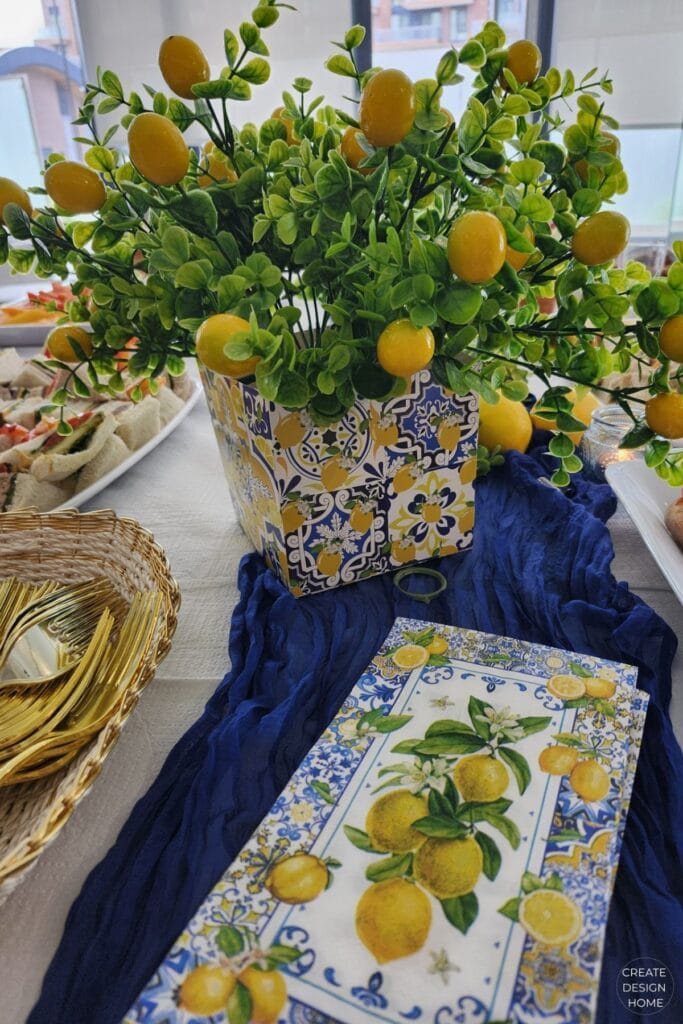 Lemon centrepiece with fresh lemons and greenery in a blue and white planter
