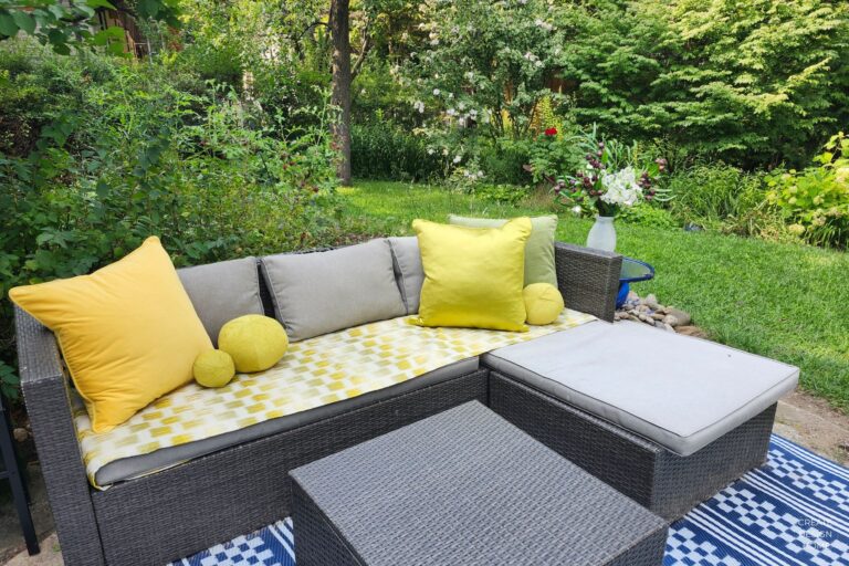Outdoor sofa styled with yellow and green cushions for summer entertaining