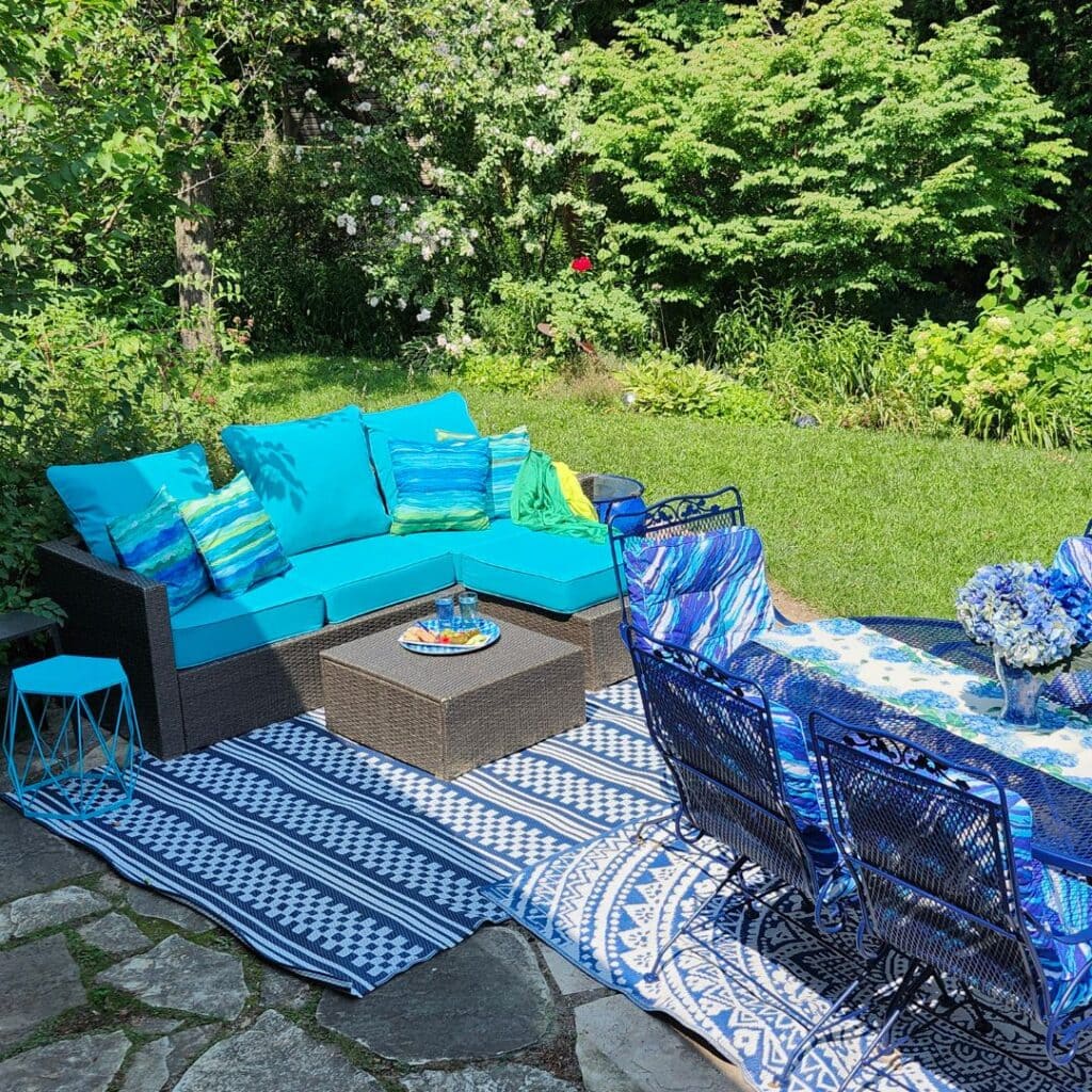 Blue and turquoise outdoor seating and dining area in a summer garden