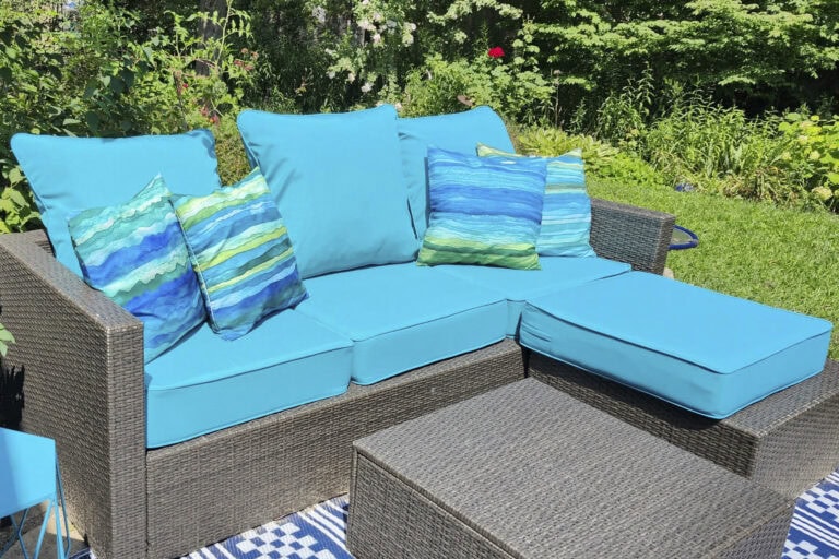 Turquoise outdoor sofa cushions with blue and green accent pillows on a wicker sectional