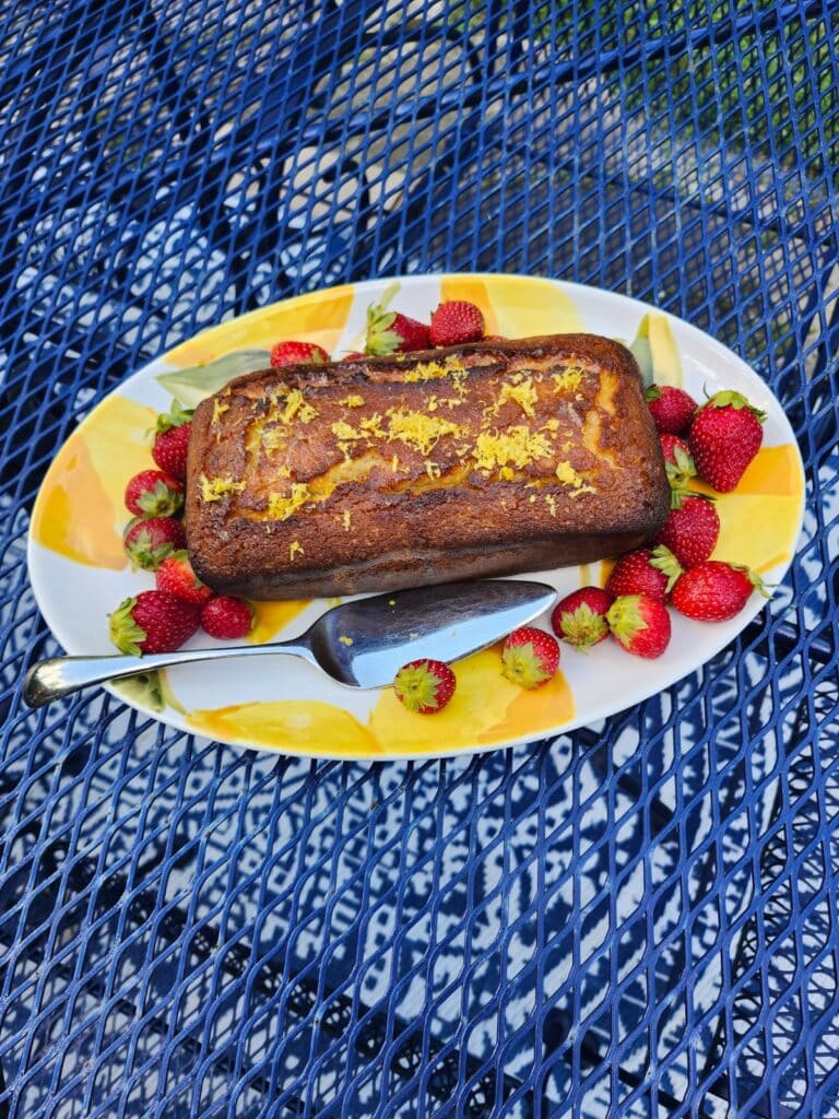 Lemon cake served with strawberries and fresh lemon slices for a summer garden party